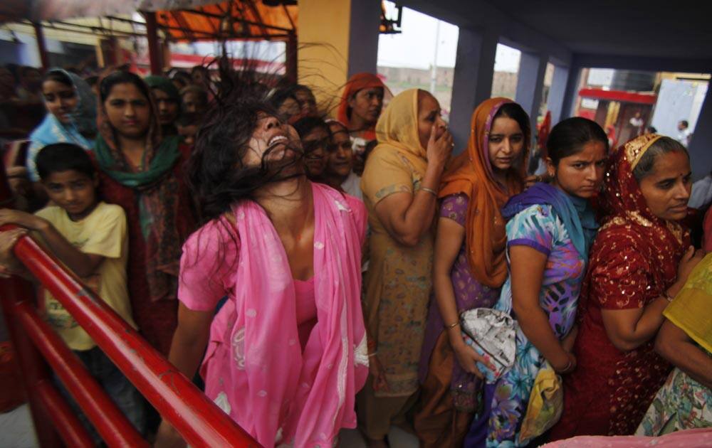 A Hindu devotee whirls her head in a trance as others wait to offer prayers at a Hindu goddess Kali temple on the second day of the Navratri festival in Jammu.