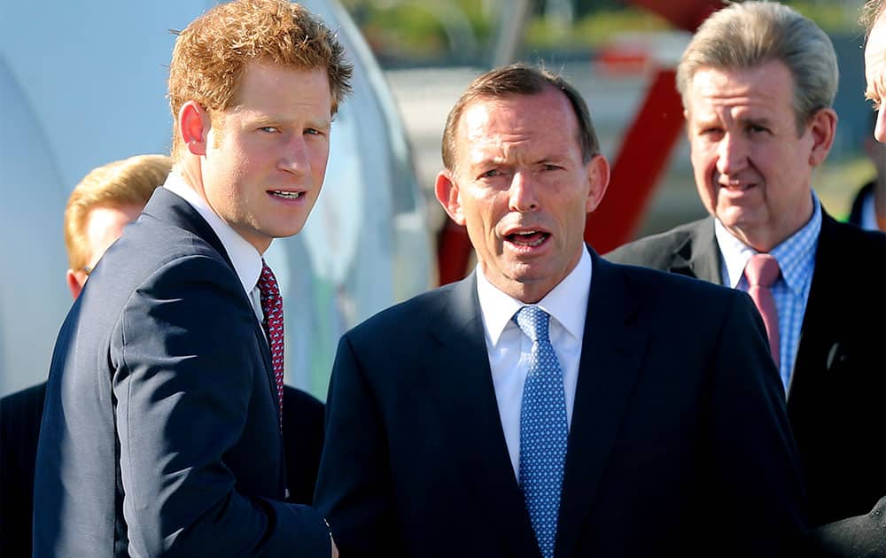 Britain`s Prince Harry, left, speaks with Australia`s Prime Minister Tony Abbott at Sydney Airport in Australia.