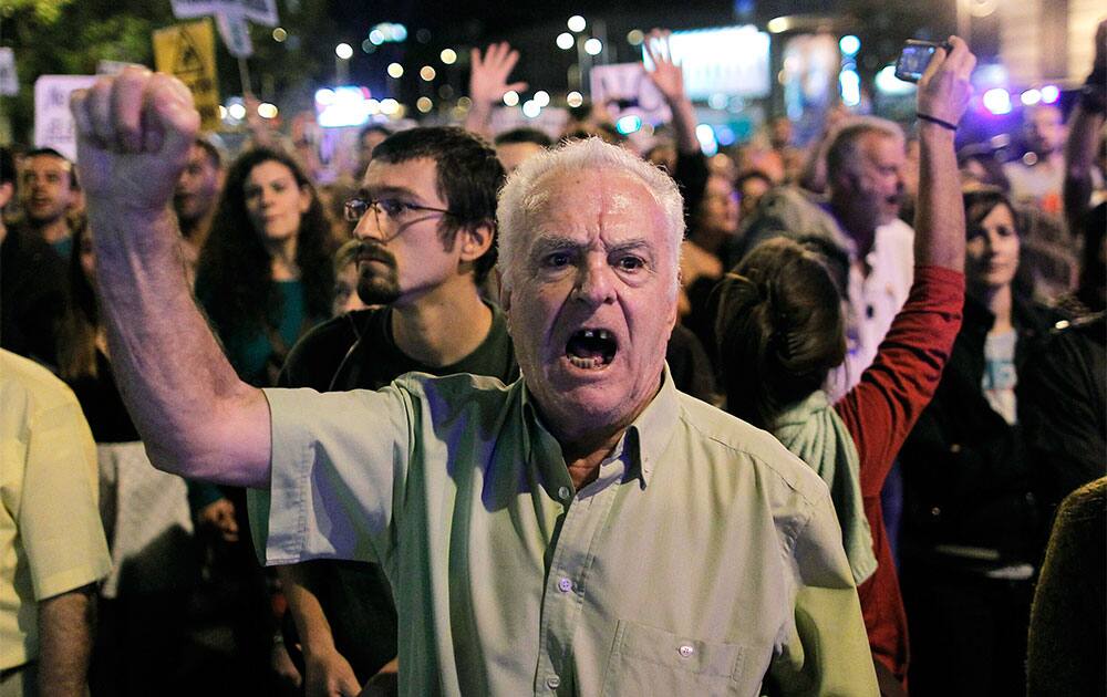 A protestor shouts slogans during a demonstration against corruption and to demand the resignation of Spanish Prime Minister Mariano Rajoy, in Madrid, Spain.