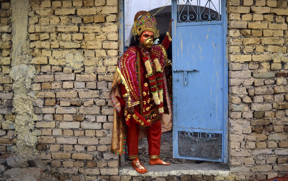 A Hindu man dressed up like God Hanuman waits to participate in a religious procession of Navratri festival in Amritsar.