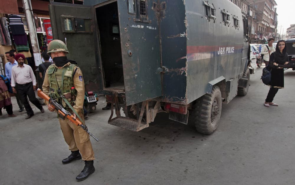 An Indian paramilitary soldier stands guard as a young Kashmiri girl stans near the police van in Srinagar. The Indian army said Saturday that it killed seven suspected rebels in two separate gunbattles near the heavily militarized line dividing the Kashmir region between India and Pakistan.