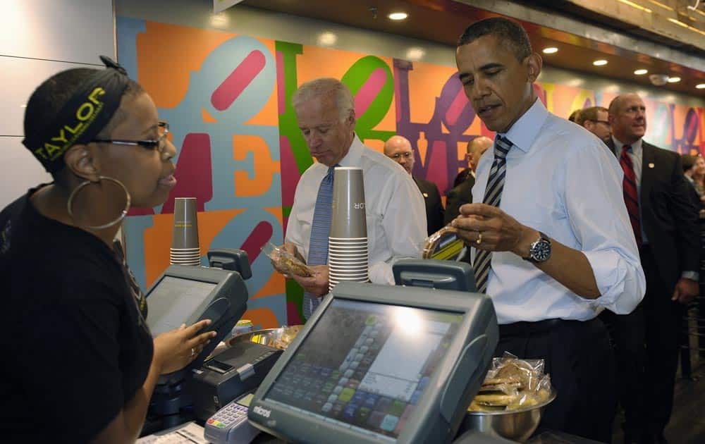 President Barack Obama tries to decide what kind of cookie to get as he and Vice President Joe Biden order lunch at Taylor Gourmet sandwich shop near the White House in Washington.