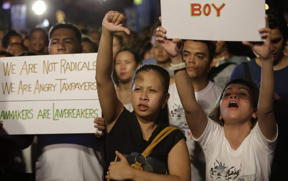 Protesters display placards during a rally to demand the scrapping of Government funds intended for development projects by lawmakers known as