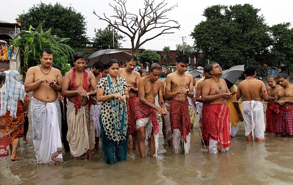 Hindu devotees offer prayers as they perform “Tarpan,” rituals for the peace of the souls of their ancestors, at the river Ganges in Kolkata.