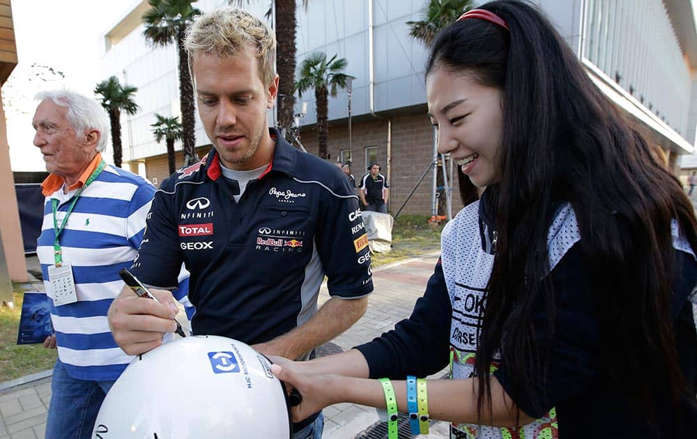 Red Bull driver Sebastian Vettel of Germany signs his autograph for a fan following the drivers meeting at the Korean Formula One Grand Prix at the Korean International Circuit in Yeongam.