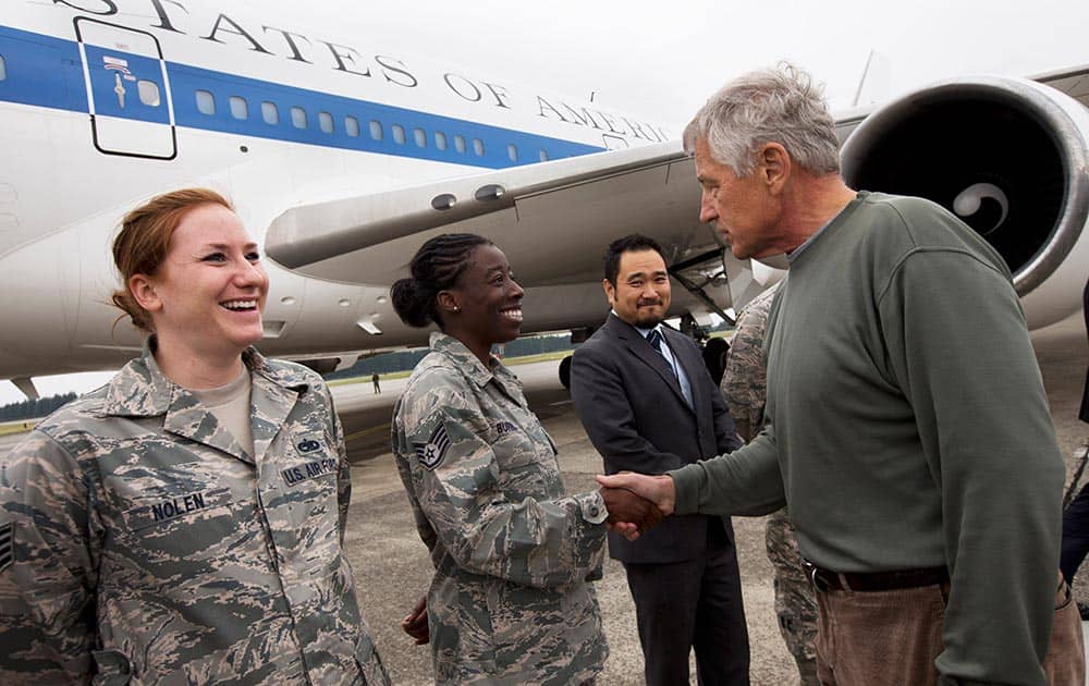 US Air Force Staff Sgt. Sheri Nolen and Staff Sgt. Denise Burris are greeted by US Secretary of Defense Chuck Hagel, as he leaves Japan to return to the US from Yokota Air Base.