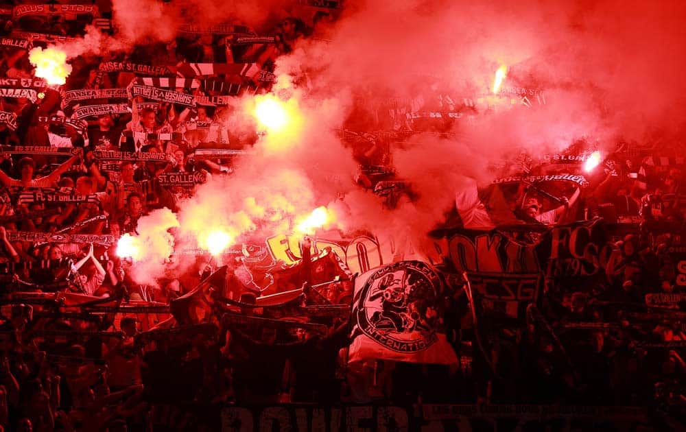 St Gallen supporters hold flares in the crowd ahead of the Europa League match against Swansea City at the Liberty Stadium.