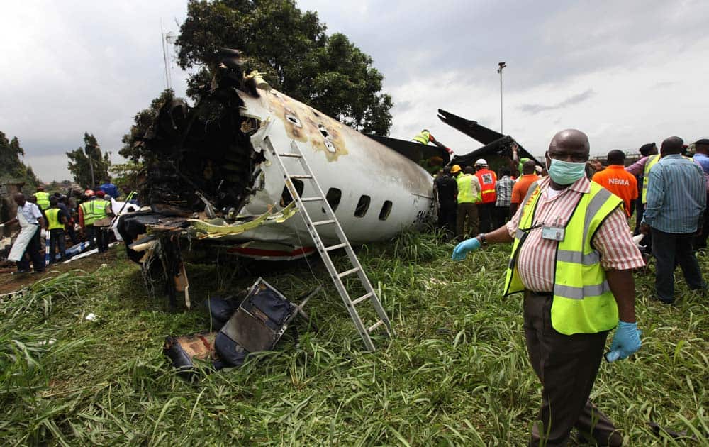 Rescue workers inspect the wreckage of a charter passenger jet which crashed soon after take off from Lagos airport, Nigeria.