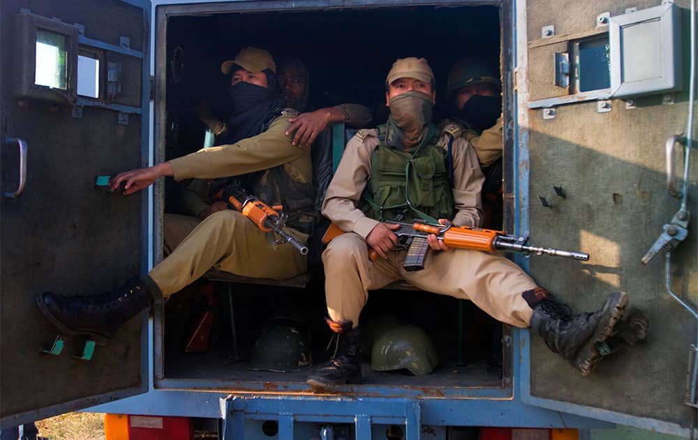 Paramilitary soldiers sit inside an armored vehicle near the site of a gun-battle in the outskirts of Srinagar. Police said that at least seven policemen were wounded in an overnight gun-battle with suspected militants in the city of Srinagar.