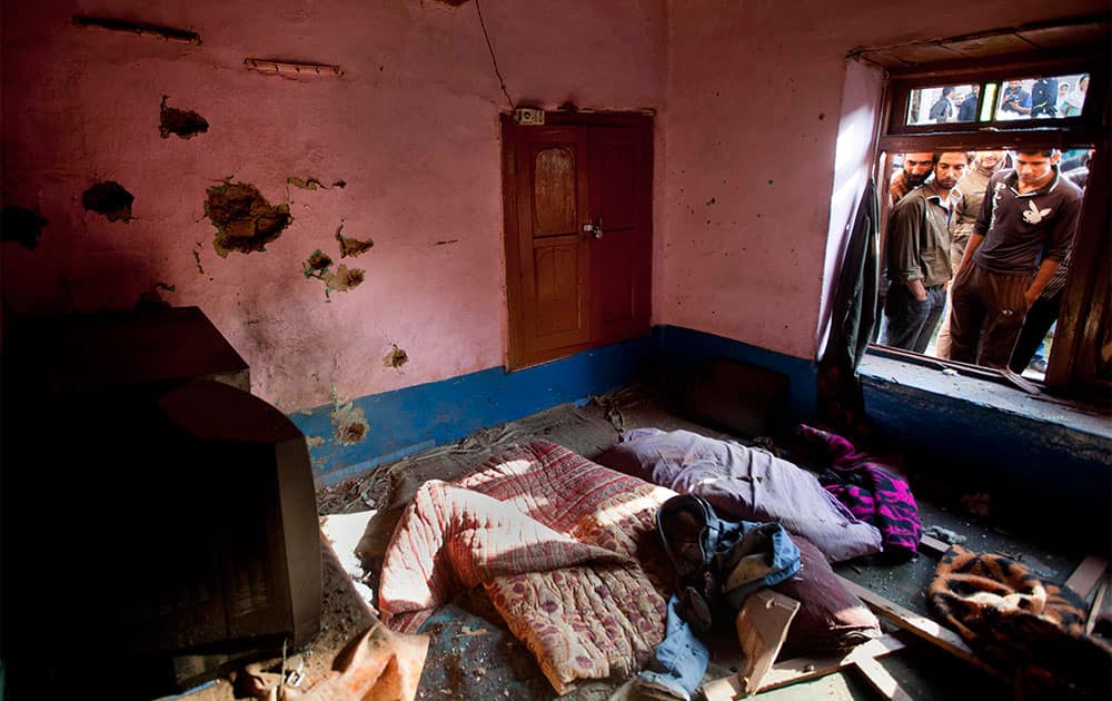 Kashmiri Muslims look at a bullet-ridden room following a gun-battle between Indian security forces and suspected militants in the outskirts of Srinagar.