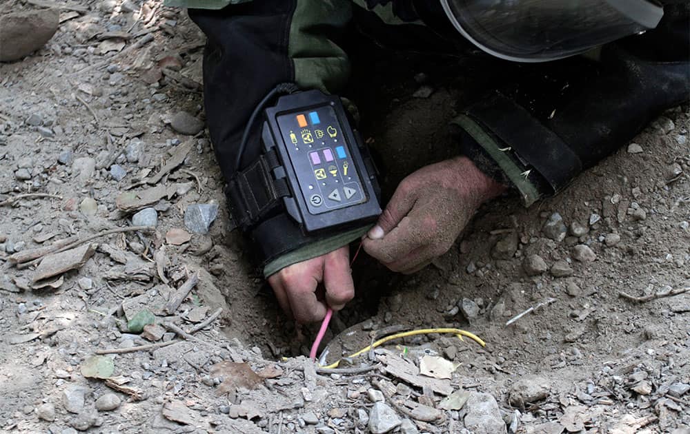 Afghan army soldier Ali Raza, 30, searches for land mines with a metal detector during an IED, or improvised explosive device, defusing training exercise in Jalalabad, east of Kabul, Afghanistan.