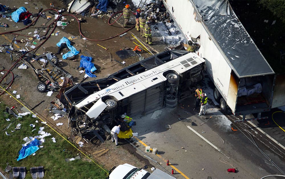 In this aerial photo, emergency workers respond to a crash involving a passenger bus, a tractor-trailer and an SUV near Dandridge, Tenn. Authorities said the bus, carrying members of a North Carolina church group, veered across the highway median and crashed into the other vehicles in a fiery wreck that killed several people.
