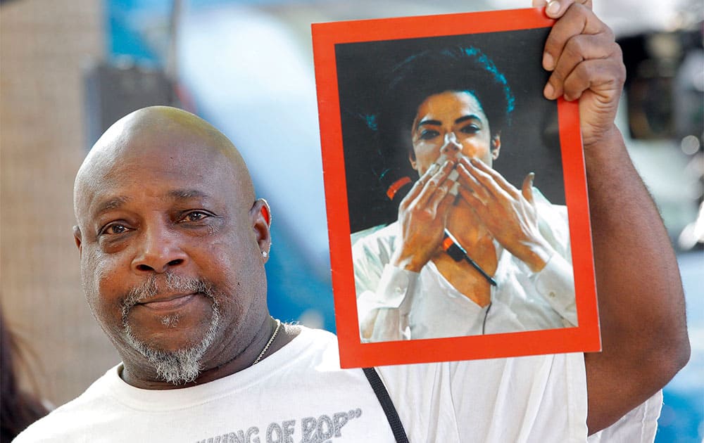 Vincent Woods, a Michael Jackson fan hold up a portrait of Jackson after the AEG Jackson trial verdict in Los Angeles.