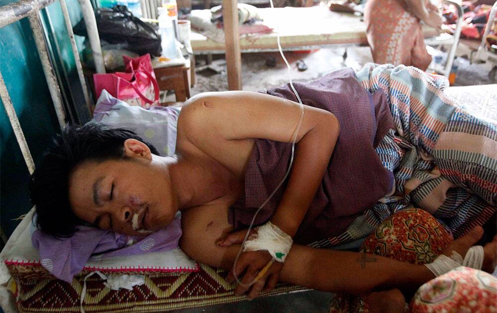 An injured Rakhine man receives medical treatment at Thandwe hospital in Thandwe, Rakhine State, western Myanmar. Terrified Muslim families hid in forests in western Myanmar on Wednesday, a day after fleeing new sectarian violence that erupted even as the president toured the divided region.