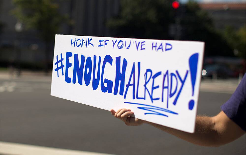 A furloughed federal worker, who did not wish to be identified, holds out a sign to passing traffic on Pennsylvania Avenue in Washington.