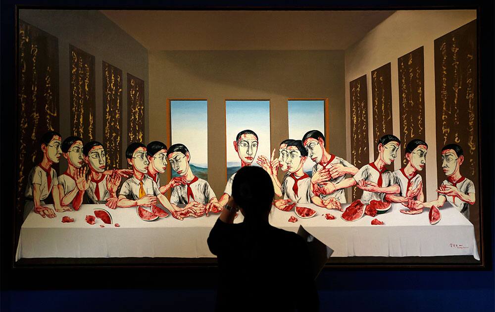A woman looks at a painting by Chinese artist Zeng Fanzhi titled