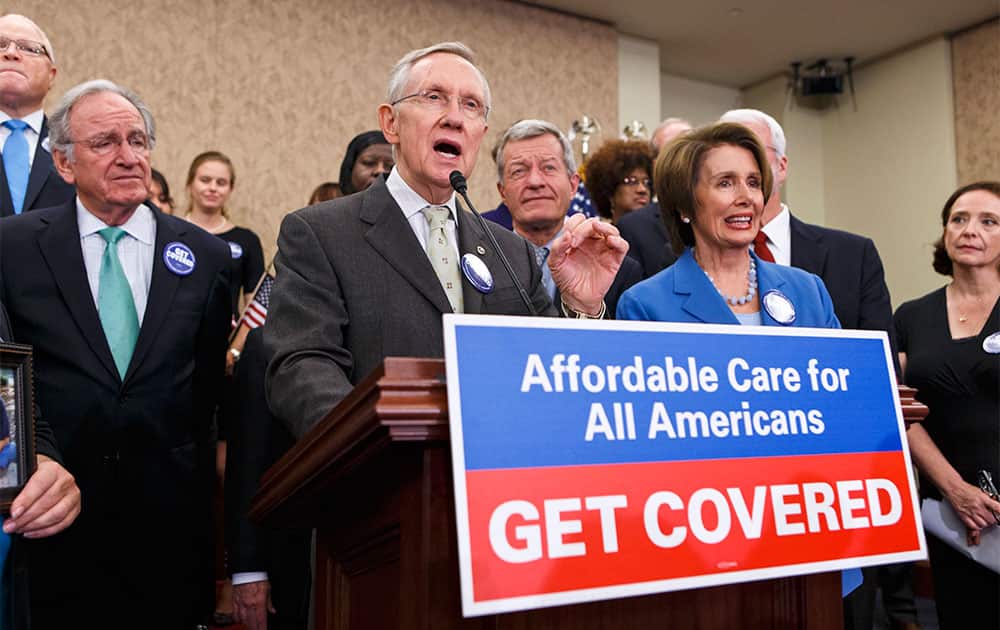 Senate Majority Leader Harry Reid, D-Nev., center, and House Minority Leader Nancy Pelosi, D-Calif., right, celebrate the start of the Affordable Care Act during an event with other lawmakers and people whose lives have been impacted by lack of health insurance, at the Capitol in Washington.