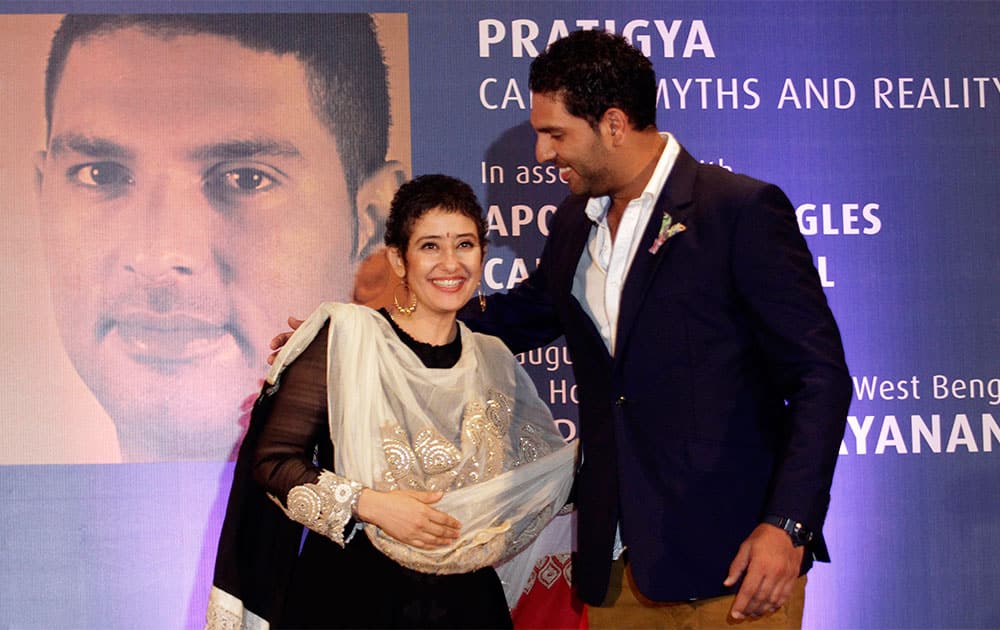 Cancer survivors Manisha Koirala, left, and Yuvraj Singh hug during an interactive session