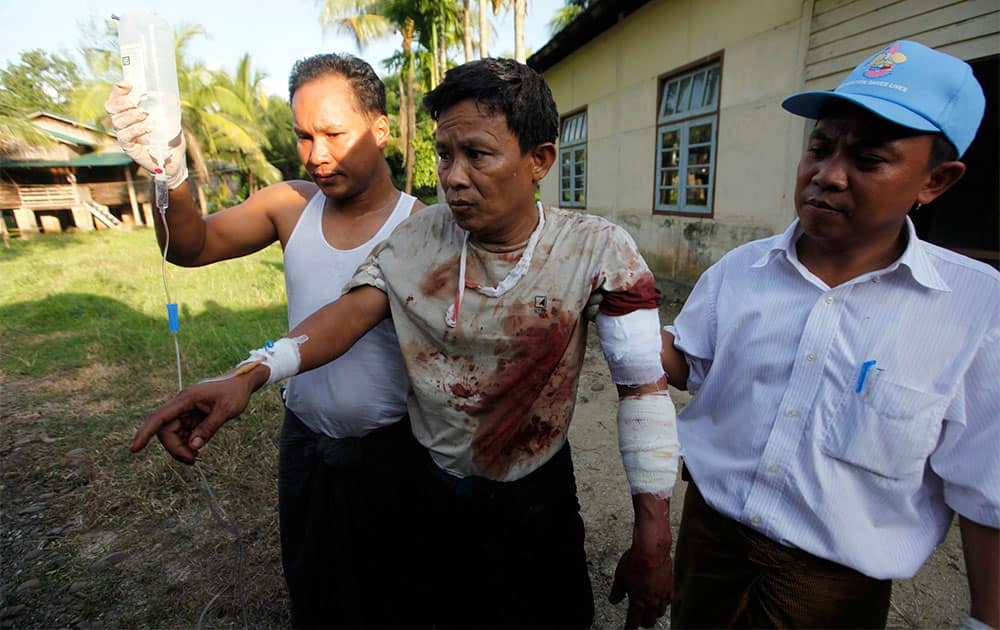 An injured Rakhine Man, centre, is helped to go to hospital in Thandwe, Rakhine State, western Myanmar. Buddhist mobs killed a 94-year-old Muslim woman and torched more than 70 homes on Tuesday as sectarian violence again gripped Myanmar`s Rakhine state despite a visit by President Thein Sein, officials and residents said.