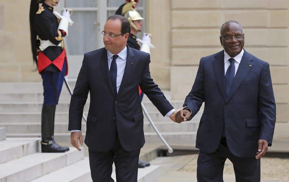 French President Francois Hollande, holds the hand of Mali President Ibrahim Boubakar Keita prior to their meeting at the Elysee Palace in Paris.