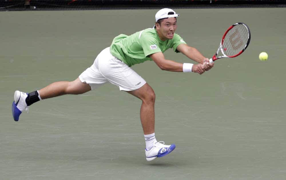 Tatsuma Ito of Japan returns the ball against Feliciano Lopez of Spain during their first round match at the Japan Open Tennis Championships in Tokyo.
