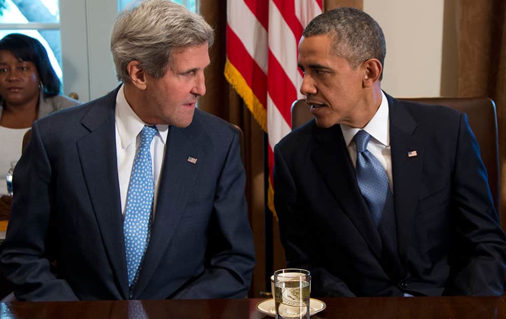 President Barack Obama talks with Secretary of State John Kerry before a cabinet meeeting in the Cabinet Room of the White House.