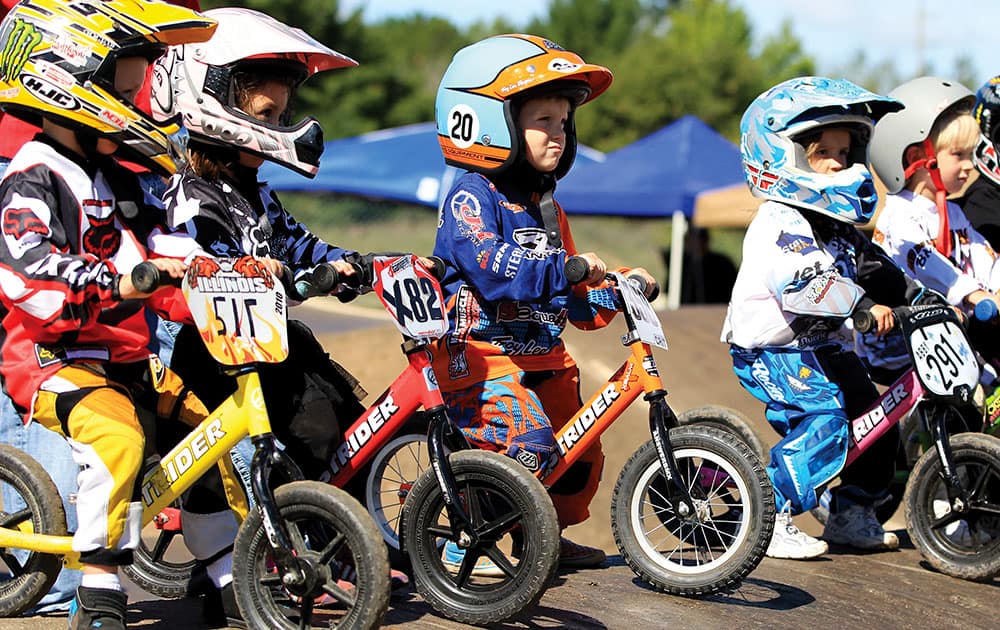 Three year old children line up for the STRIDER race at the 2012 USA BMX Badger State Nationals held in Wisconsin Rapids, Wis. Gathered at the starting line, they look like mini versions of BMX racers, decked out in helmets, jerseys and protective gear with number plates on their tiny bikes.