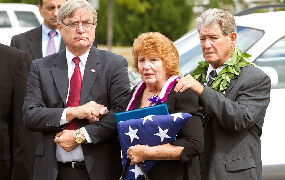Shirley Ridgell and her husband Dick Ridgell, right, are comforted by their friend Michael W. Beasley, left, after the funeral service of their son Richard Michael Ridgell, 52, of Westminster, Md. at The Church at Severn Run, in Severn, Md.