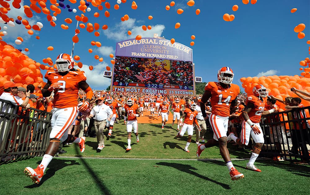 Clemson defensive tackle Tavaris Barnes (9), defensive back Martin Jenkins (14) and cornerback Garry Peters (26) run to the field before an NCAA college football game against Wake Forest, in Clemson, S.C.