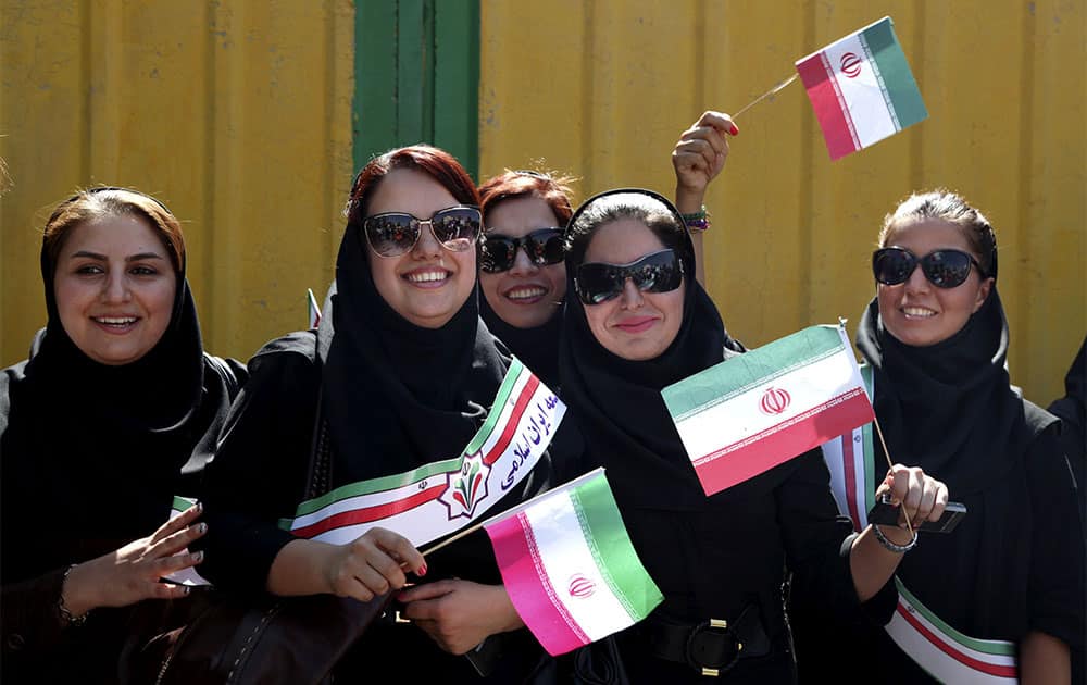 Supporters of Iranian President Hassan Rouhani, wave Iranian flags, upon his arrival from the U.S. near the Mehrabad airport in Tehran, Iran.