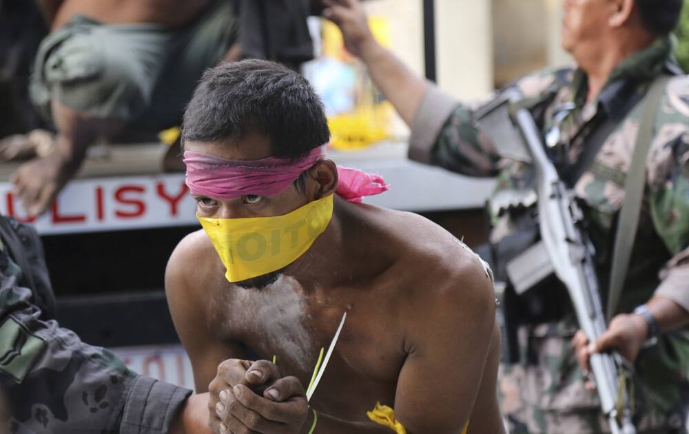 Suspected Muslim rebels whom the military said were either captured or surrendered, arrive at a police station for processing in Zamboanga city, southern Philippines.