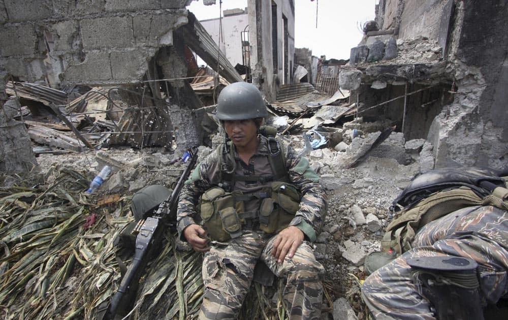 A government trooper rests amidst the ruins at the site of a three-week standoff in Zamboanga city, southern Philippines.