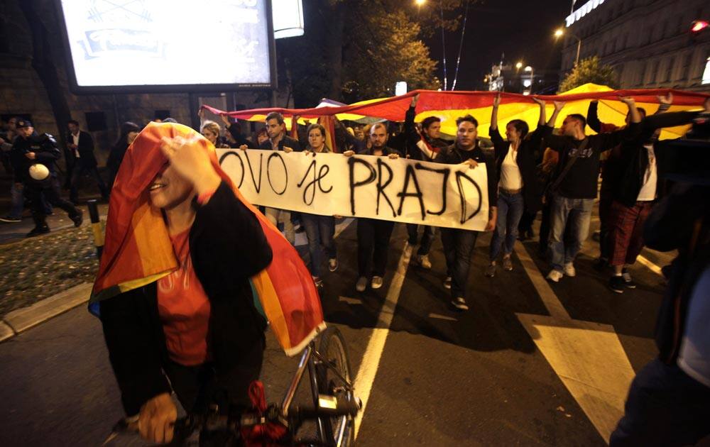 Gay rights activists hold up rainbow flags and a banner reading