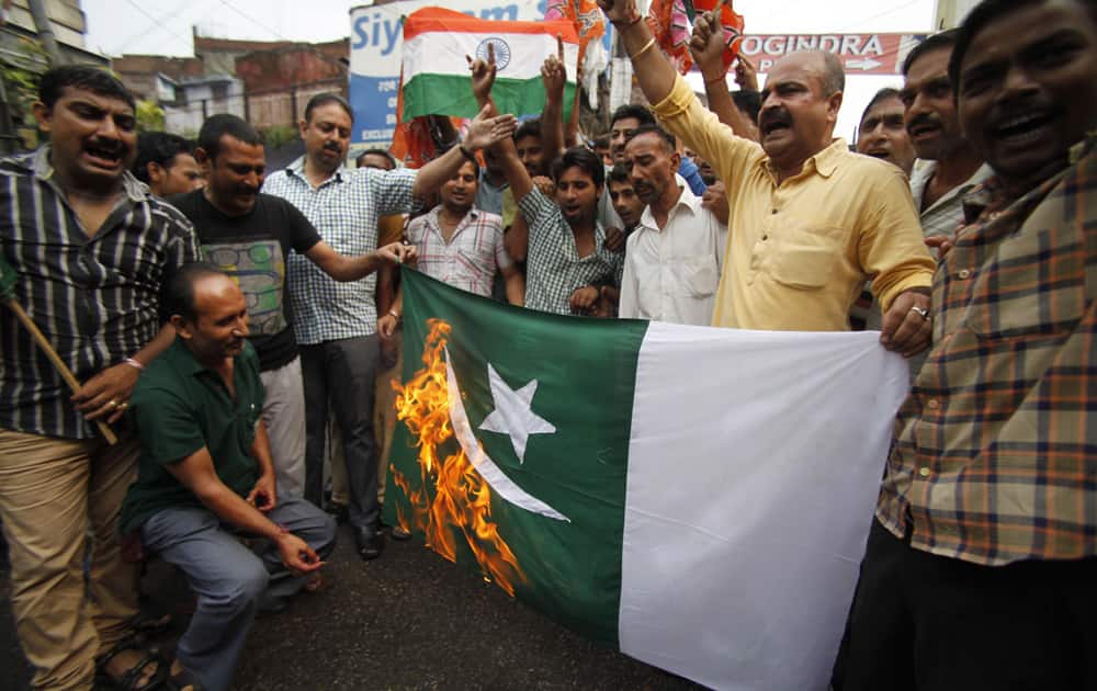 Youth wing activists of India`s main opposition Bharatiya Janata Party burn a Pakistani national flag during a protest against Thursday’s attack by terrorists in Kashmir, in Jammu.