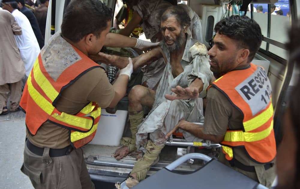 Pakistani rescue worker carry a man who was injured in a bomb blast into a hospital in Peshawar, Pakistan.