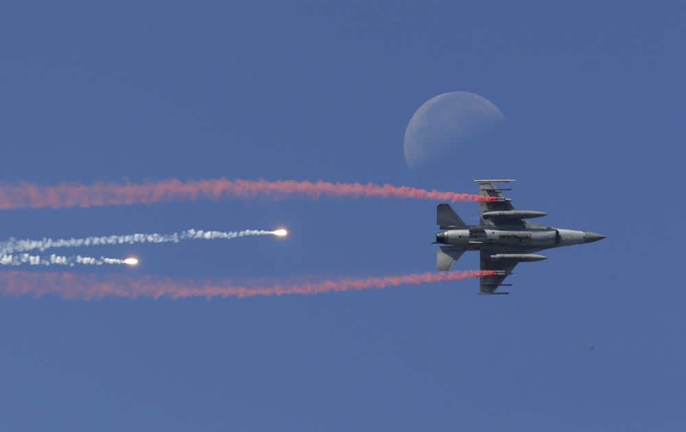 A South Korean Air Force F-16 fighter jet fires flare shells past the moon during the media day for the 65th anniversary of Armed Forces Day at Seoul military airport in Seongnam, South Korea.