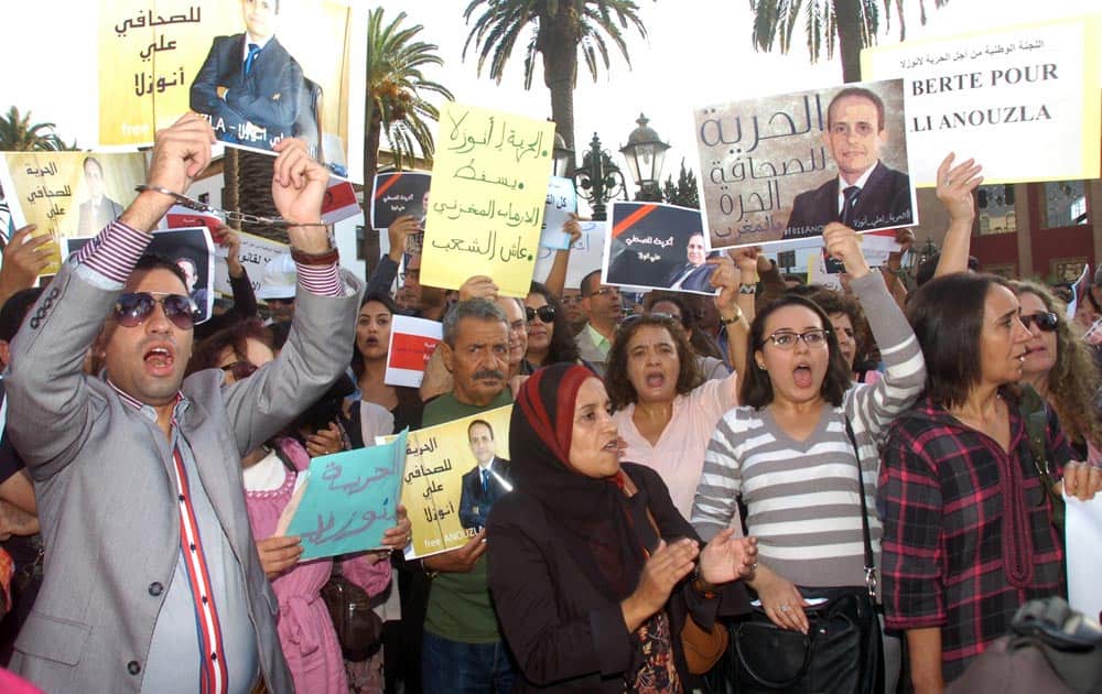 Anti-government protesters shout as they in front of parliament as they hold a portrait of Morocco`s editor Ali Anouzla who is arrested for posting al-Qaida video last week in Rabat, Morocco.