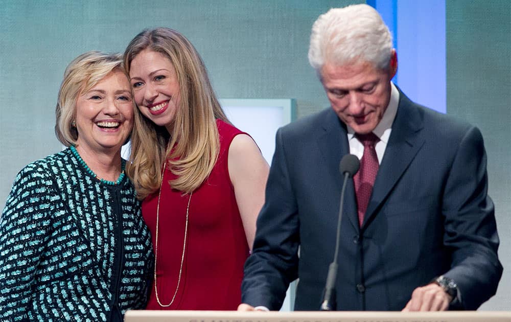 Former President Bill Clinton prepares to make remarks at the Clinton Global Initiative while his wife, Hillary Rodham Clinton, and daughter, Chelsea, take the stage with him, in New York.