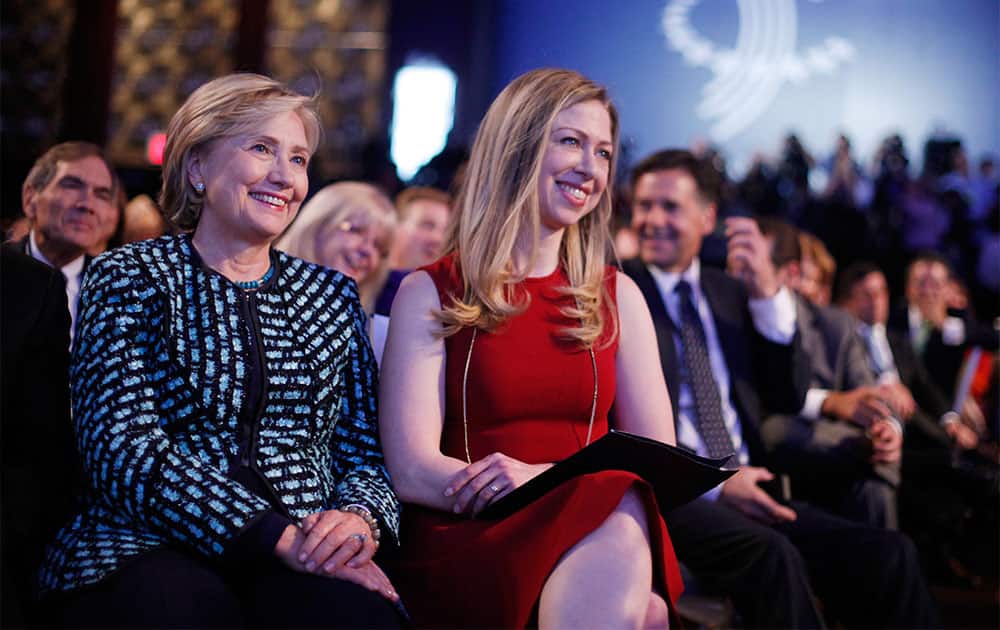 Former Secretary of State Hillary Rodham Clinton, left, and her daughter Chelsea Clinton, center, listen to President Barack Obama and former President Bill Clinton speak at the Clinton Global Initiative in New York.