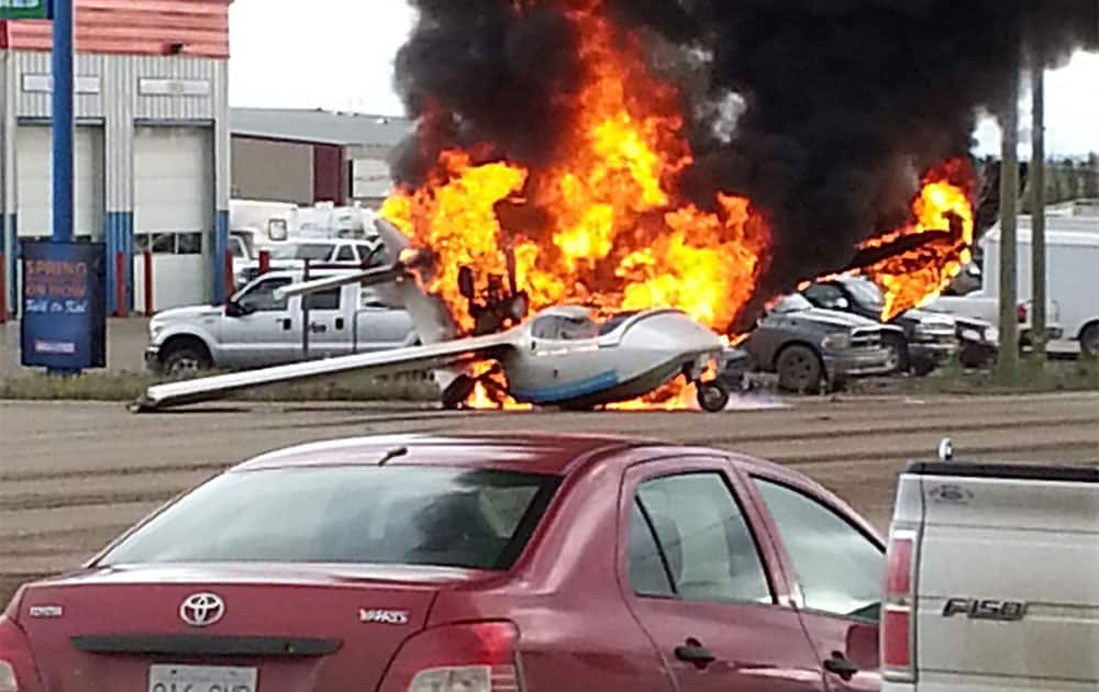 A plane is engulfed in flames in the middle of an intersection in Fort Nelson, British Columbia. Police in British Columbia say a pilot suffered only minor injuries.