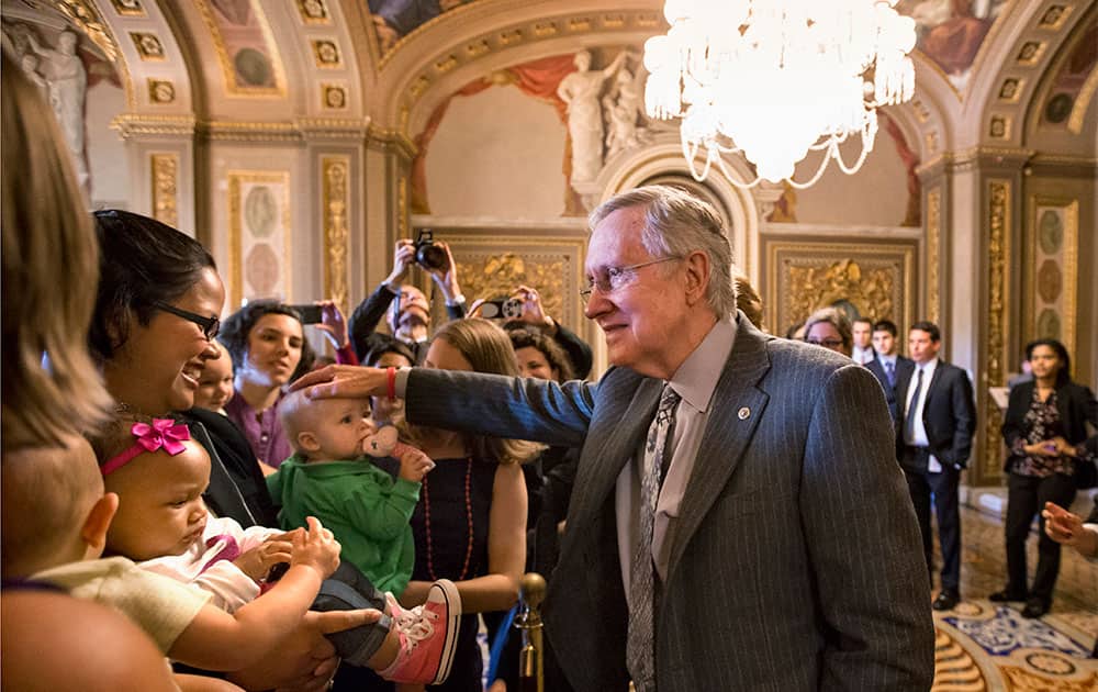 Senate Majority Leader Harry Reid of Nev., and other lawmakers meet with new mothers and their babies on Capitol Hill in Washington.
