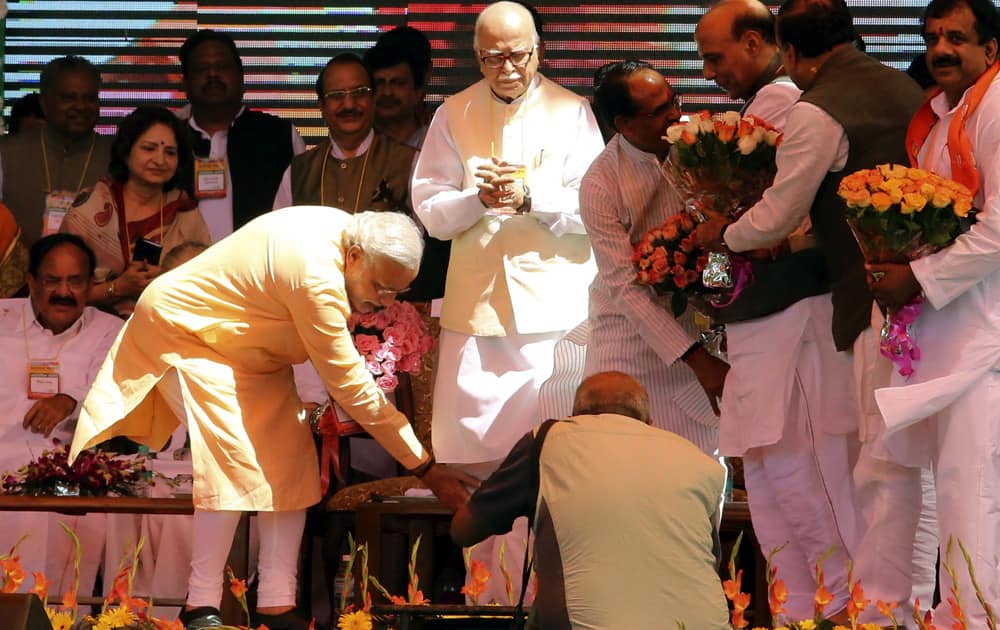 Gujarat state Chief Minister Narendra Modi bows to touch the feet of senior leader Lal Krishna Advani as a sign of respect at a rally in Bhopal.