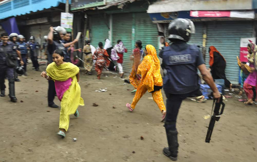 Bangladeshi garment workers run as police disperse them during a protest march in Narayanganj, near Dhaka, Bangladesh.