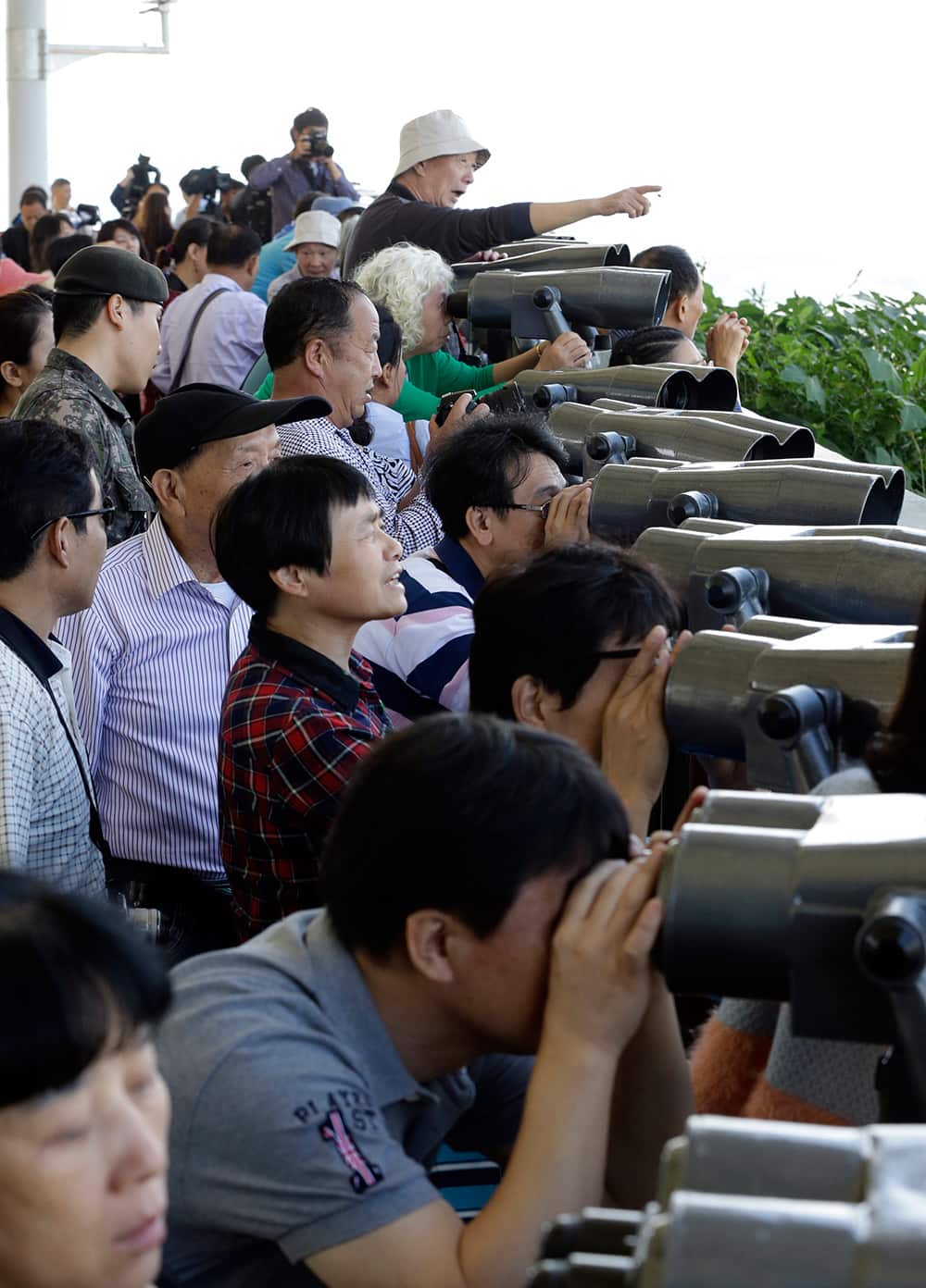 Visitors look over North Korea through binoculars from the Dora Observation Post in Paju near the border village of Panmunjom, which has separated the two Koreas since the Korean War, in Paju, north of Seoul, South Korea.