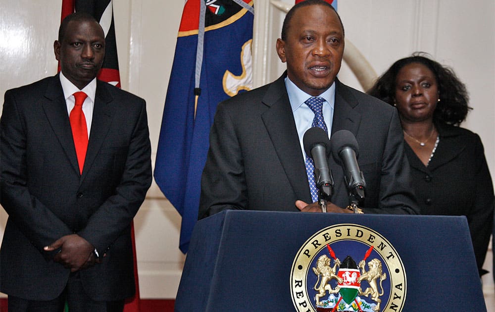 Kenyan President Uhuru Kenyatta, center, flanked by Deputy President William Ruto, left, and other senior Government and Security officials, makes a television address to the nation from State House in Nairobi, Kenya.