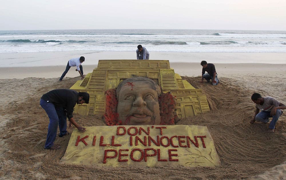Indian sand artist Sudarshan Pattnaik, foreground left and his team pay tributes to the victims of the terror attack on a Kenya mall by creating a sand sculpture on the Bay of Bengal coast in Puri, Orissa state, India.