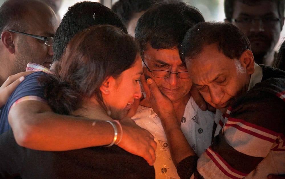 Ramesh Vaya, center, is comforted by family members after lighting the funeral pyre for his wife Malti, who was shot dead in the attack on the Westgate Mall, at her funeral at the Hindu Crematorium in Nairobi, Kenya.