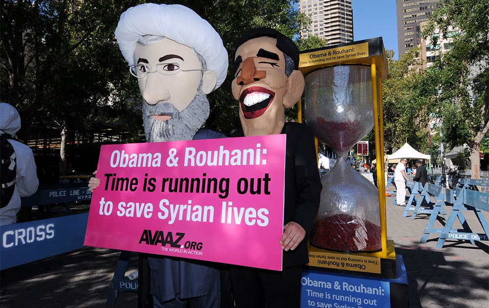 Campaigners from the global advocacy group Avaaz, dressed as Presidents Obama and Rouhani, demand the two leaders negotiate a ceasefire to the Syrian crisis during the United Nations General Assembly in Dag Hammarskjold Plaza in New York City.