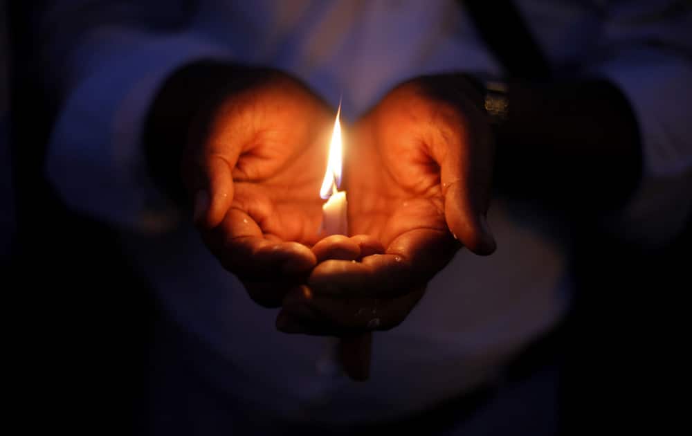 An Indian Christian holds a candle in solidarity with the victims of Sunday’s suicide attack on a church in Pakistan, outside the Sacred Heart Cathedral in New Delhi.