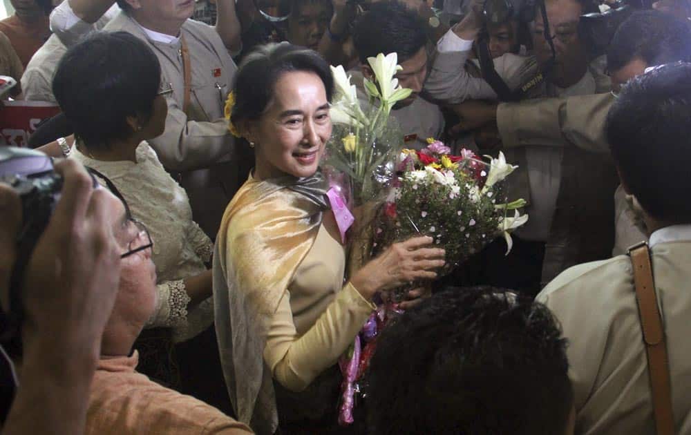Myanmar Opposition leader Aung San Suu Kyi, is surrounded by her party supporters upon her arrival back from Singapore, at Yangon International airport in Yangon, Myanmar.